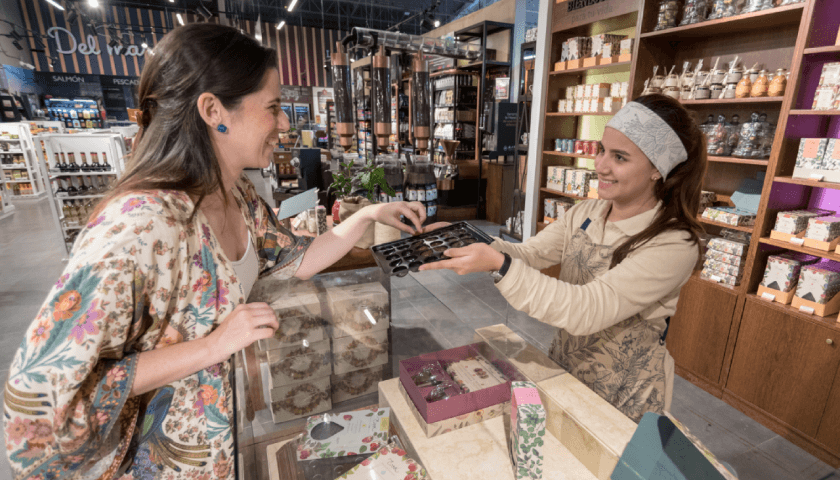 Foto de una mujer comprándole a otra mujer
